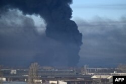 Asap hitam mengepul dari bandara militer di Chuguyev dekat Kharkiv pada 24 Februari 2022. (Foto: AFP)