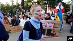 Olena Avtukh joins others in prayer during a protest of the Russian invasion of Ukraine held at the state Capitol in Sacramento, Calif., Feb. 24, 2022.