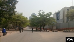 Armed security men stand guard on a road that leads to the Russian consulate in Abuja, Nigeria, Feb. 28, 2022. (Timothy Obiezu/VOA)