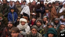 FILE - Hundreds of Afghan men gather to apply for humanitarian aid in Qala-e-Naw, Afghanistan, Dec. 14, 2021.