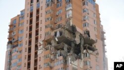 Sebuah gedung apartemen rusak akibat serangan roket di kota Kyiv, Ukraina, Sabtu, 26 Februari 2022. (Foto: AP)