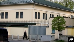 FILE - A man walks past the U.S. Embassy in Minsk, May 1, 2008.