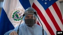 Un trabajador de la salud desinfecta el podio y los micrófonos antes de una conferencia de prensa ofrecida por la embajada de Estados Unidos en en San Salvador, el 26 de mayo de 2020.
