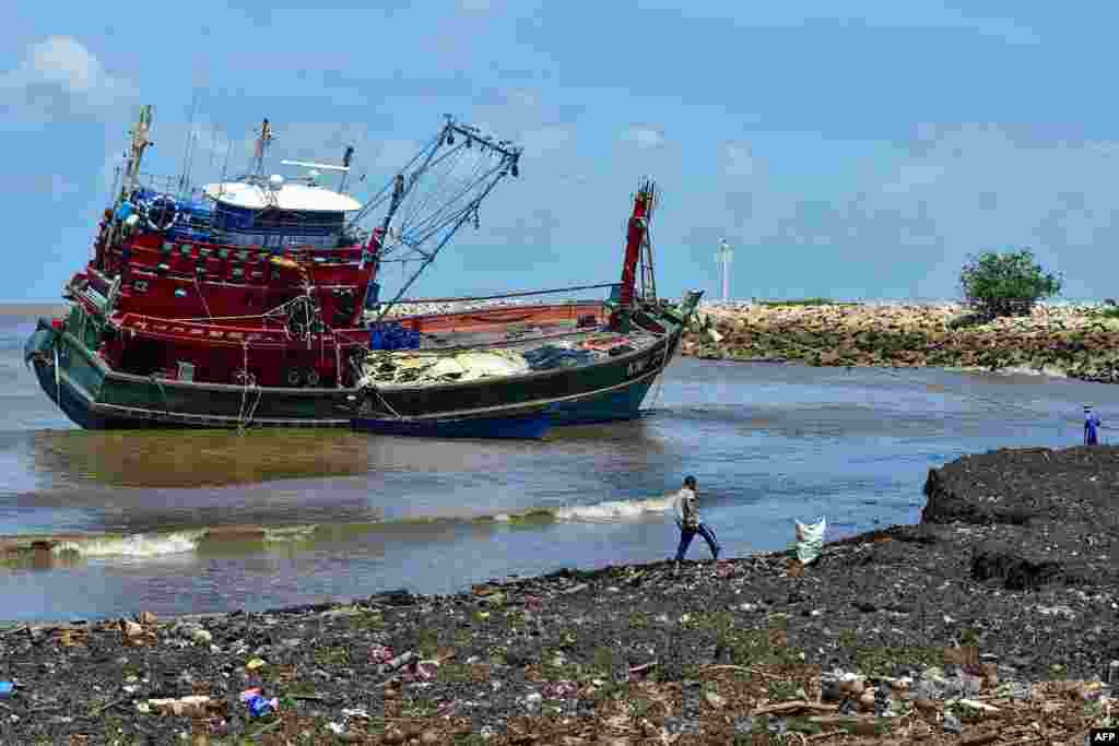 A Malaysian fishing boat is seen close to the shore, after being hit by strong winds and rain overnight, in Takbai district in the southern Thai province of Narathiwat.