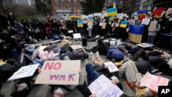 Protesters lie down on the ground during a rally against Russia's invasion of Ukraine, near the Russian Embassy in Seoul, Feb. 28, 2022.