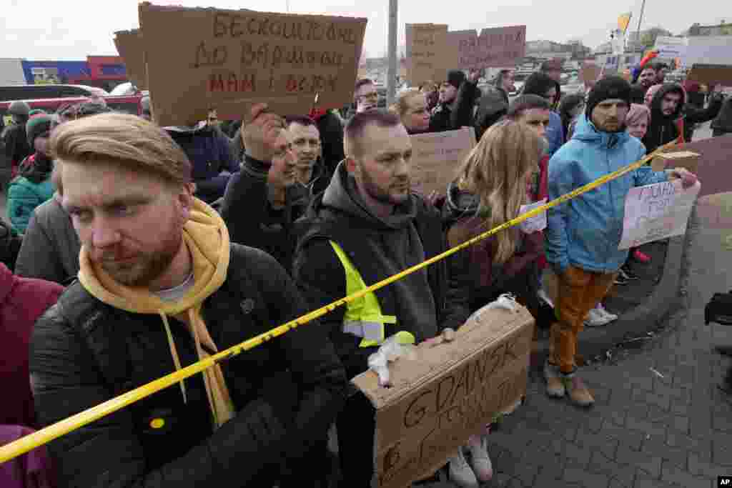 People holding placards offer transportation to refugees from Ukraine at the Korczowa border crossing, Poland, Feb. 27, 2022. 