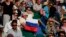 FILE - A spectator holds up a Russian flag as he watches a men's singles match on between Russia and Croatia at the Wimbledon Tennis Championships in London, July 3, 2021.