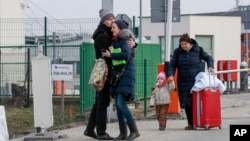 Family members hug as they reunite, after fleeing conflict in Ukraine, at the Medyka border crossing, in Poland, Feb. 27, 2022.