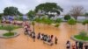 Warga mengarungi banjir saat mengungsi pasca banjir di Serang, Provinsi Banten, pada 1 Maret 2022. (Foto: AFP/Dziki Oktomauliyadi)