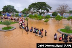 Warga mengarungi banjir saat mengungsi pasca banjir di Serang, Provinsi Banten, 1 Maret 2022. (Foto: AFP/Dziki Oktomauliyadi)