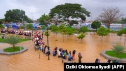 Warga mengarungi banjir saat mengungsi pasca banjir di Serang, Provinsi Banten, pada 1 Maret 2022. (Foto: AFP/Dziki Oktomauliyadi)