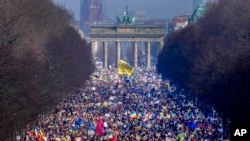 Njerëzit ecin nëpër bulevardin 'Strasse des 17. Juni' përpara një mitingu kundër pushtimit rus të Ukrainës në Berlin, Gjermani, të dielën, 27 shkurt 2022. (AP Photo/Markus Schreiber)