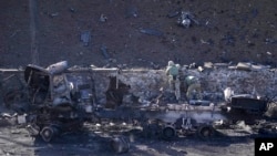 烏克蘭士兵檢查被俄軍摧毀的車輛。