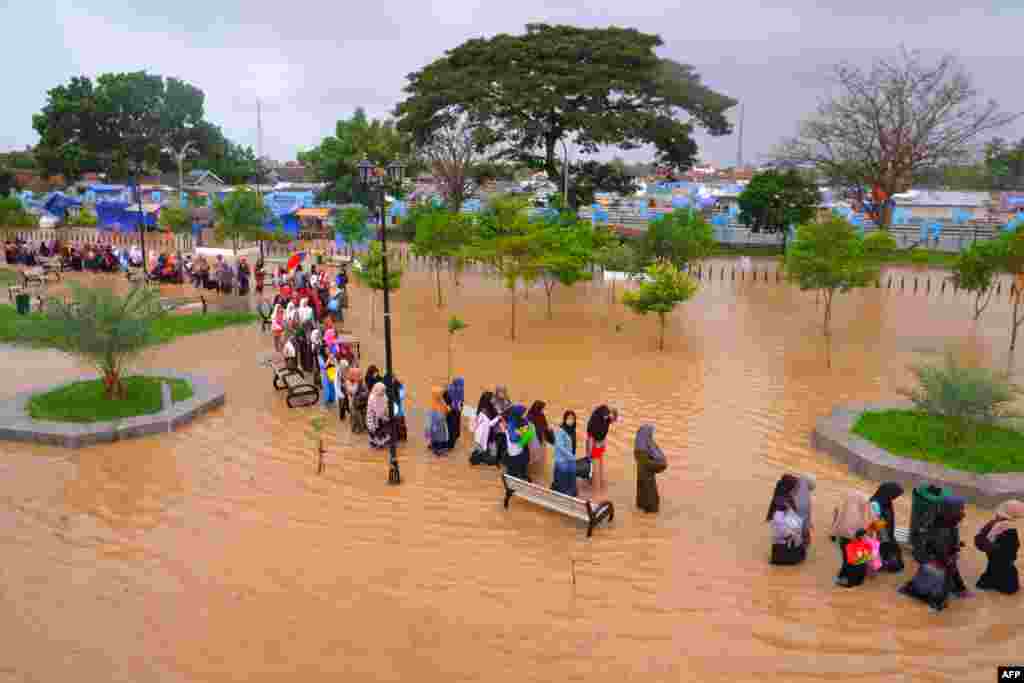 People wade through floodwaters in Serang, Banten province, Indonesia.