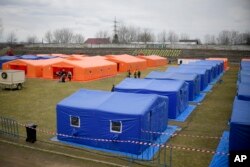 Tempat penampungan sementara untuk pengungsi Ukraina didirikan di lapangan sepak bola di Siret, Rumania, 27 Februari 2022. (AP/Andreea Alexandru)