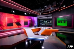 FILE - An anchor of the state-controlled RT (formerly Russia Today) TV company is seen as he prepares to go on the air in one of the broadcaster's studios, in Moscow, June 8, 2018.