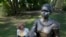 FILE - In this photo taken Aug. 25, 2016, JerriAnne Boggis stands next to a statue of Harriet Wilson in Milford, N.H. 