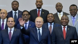 Russian President Vladimir Putin gestures as Egypt's President Abdel Fattah al-Sisi (L) and South African President Cyril Ramaphosa (R) pose for a family photo with African leaders attending 2019 Russia-Africa Summit and Economic Forum in Sochi, Oct 24, 2019. 