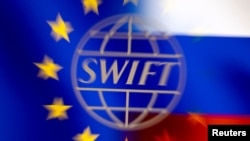 Swift logo is pictured with EU and Russian flags in this illustration picture taken February 26, 2022. 