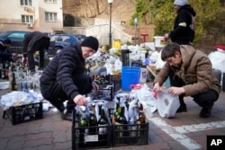 Members of civil defense prepare Molotov cocktails in a yard in Kyiv, Ukraine, Feb. 27, 2022.