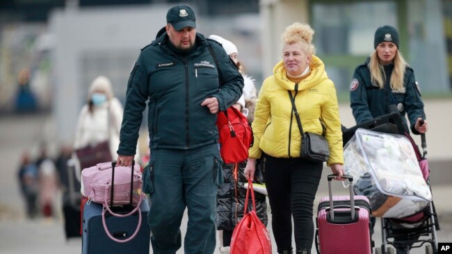 Polisi Polandia membantu para pengungsi Ukraina yang melarikan diri dari perang di negaranya di kota Medyka, Polandia (foto: dok).