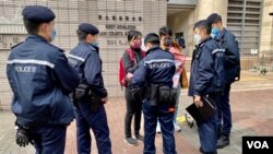 防疫二人限聚令下，社民連主席陳寶瑩與成員余煒彬在西九龍裁判法院外結束請願行動後，數名警員隨即上前將他們包圍，要求搜查隨身物品。(美國之音 湯惠芸)