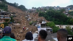 Rescue workers and residents search for victims in an area affected by landslides in Petropolis, Brazil, Feb. 16, 2022. In just three hours, the mountainous city nestled in the forest behind Rio de Janeiro, received on Feb. 15 over 10 inches of rainfall – more than ever registered in a single day since authorities began keeping records in 1932. (AP Photo/Silvia Izquierdo, File)