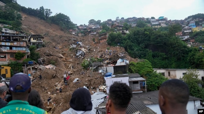 Rescue workers and residents search for victims in an area affected by landslides in Petropolis, Brazil, Feb. 16, 2022. In just three hours, the mountainous city nestled in the forest behind Rio de Janeiro, received on Feb. 15 over 10 inches of rainfall – more than ever registered in a single day since authorities began keeping records in 1932. (AP Photo/Silvia Izquierdo, File)