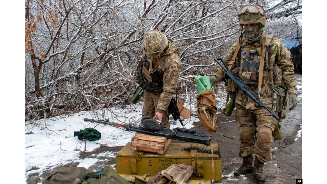 Tentara Ukraina sedang membenahi peralatan di luar Kharkiv, Ukraina, 26 Februari 2022. (Foto: AP)