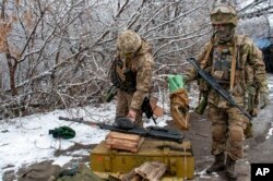 Tentara Ukraina sedang membenahi peralatan di luar Kharkiv, Ukraina, 26 Februari 2022. (Foto: AP)