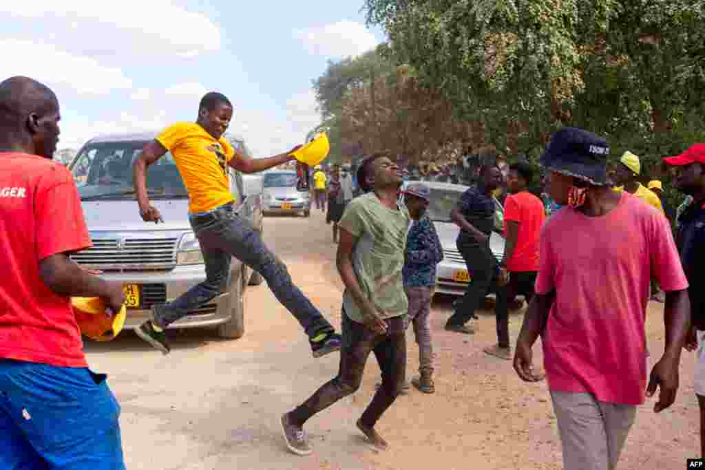 A man, suspected of being a ruling ZANU-PF attacker, reacts after being kicked by a supporter of the opposition Citizens Coalition for Change during an electoral rally at Mbizo shopping center in Kwekwe, Zimbabwe.