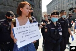 FILE - Police officers detain Yelena Chernenko, a Kommersant journalist, during a protest near the building of the Federal Security Service in Moscow, Russia, July 7, 2020.