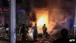 Onlookers gather near the site of an explosion, which killed three people and wounded several others according to media reports, at a market area in Quetta on March 2, 2022. 