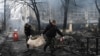 Police officers remove the body of a person killed in a March 1, 2022, airstrike that hit Kyiv's main television tower, March 2, 2022.
