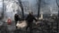 Police officers remove the body of a person killed in a March 1, 2022, airstrike that hit Kyiv's main television tower, March 2, 2022.