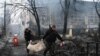Petugas polisi memindahkan mayat seorang korban tewas dalam serangan Rusia pada sebuah menara televisi di Kyiv, Ukraina, pada 2 Maret 2022. (Foto: AFP/Aris Messinis)