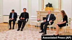 Russian President Vladimir Putin, center right, and Pakistan's Prime Minister Imran Khan, center left, talk during their meeting in Moscow, Feb. 24, 2022.