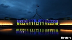 Australia’s Parliament House is seen illuminated with the colors of Ukraine's flag in solidarity with the country's people and government after Russia's invasion of Ukraine, in Canberra, Australia, Feb. 28, 2022.