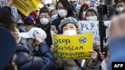 Aktivis memegang plakat dalam aksi unjuk rasa memprotes invasi Rusia ke Ukraina, di dekat kedutaan Rusia di Tokyo, Jepang, 25 Februari 2022. (Charly TRIBALLEAU / AFP)