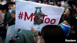 A protester raises a placard reading "#MeToo" during a rally against harassment at Shinjuku shopping and amusement district in Tokyo, Japan, April 28, 2018.