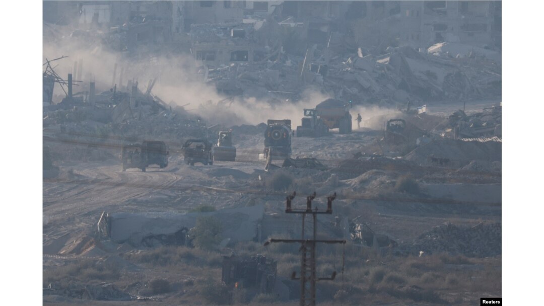 Israeli military vehicles and machinery drive inside Gaza, near the Israel-Gaza border, as seen from Israel, July 3, 2024.