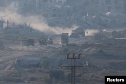 Israeli military vehicles and machinery drive inside Gaza, near the Israel-Gaza border, as seen from Israel, July 3, 2024.