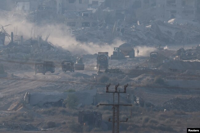 Israeli military vehicles and machinery drive inside Gaza, near the Israel-Gaza border, as seen from Israel, July 3, 2024.