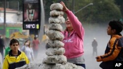 Seorang perempuan membuat menara dari es di wilayah Aclimacao, Sao Paulo, Brazil. Hujan es disertai angin ribut melanda wilayah ini sepanjang malam (19/5).