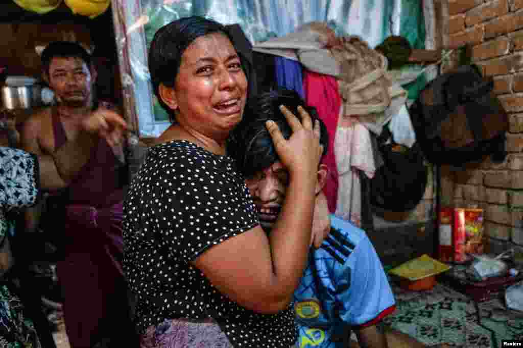 Family members cry in front of a man after he was shot dead during a crackdown on an anti-coup protesters by security forces in Yangon, Myanmar, March 27, 2021.
