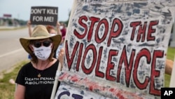 Protesters against the death penalty gather in Terre Haute, Ind., Wednesday, July 15, 2020. A U.S. judge has halted the execution of a federal death row inmate whose lawyers argue suffers from dementia. Wesley Ira Purkey was scheduled to be the…