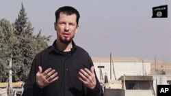 FILE - In this still image taken from an undated video published on the Internet by the Islamic State group militants, captive British journalist John Cantlie speaks into a camera in what he identifies as the embattled Syrian town of Kobani. 