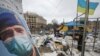 Ukrainian service members stand guard outside the regional administration building, which city officials said was hit by a missile attack, in central Kharkiv on March 1, 2022. (Vyacheslav Madiyevskyy/Reuters)