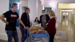 Chefs Gilbert Benhouda and Yoanne Flament consult their food delivery with Foch hospital deputy director Floriane de Dedelsen. (Photo: Lisa Bryant / VOA)