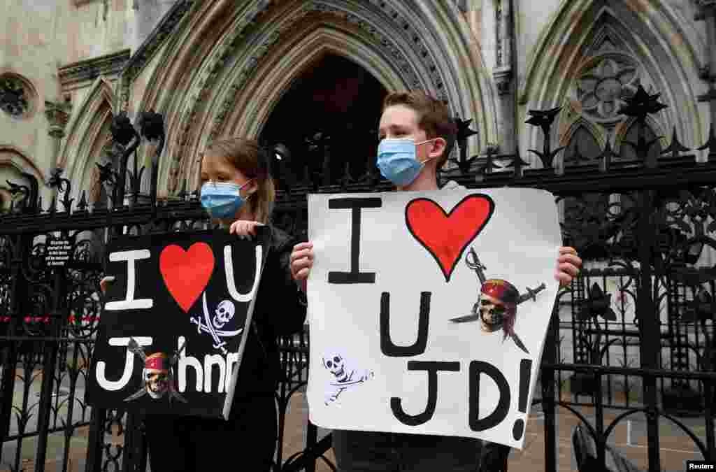 Fans of actor Johnny Depp hold placards as they wait for him to arrive at the Supreme Court, in London.